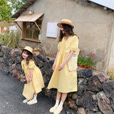 Matching summer dress for mother and daughter with a light yellow check pattern, puff midi sleeves and a wide colar