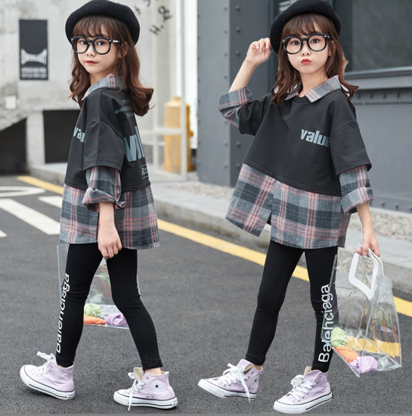 A two-piece set for girls, one piece T-shirt style shirt, a long-sleeved shirt with a check pattern, and black leggings with writing on the side