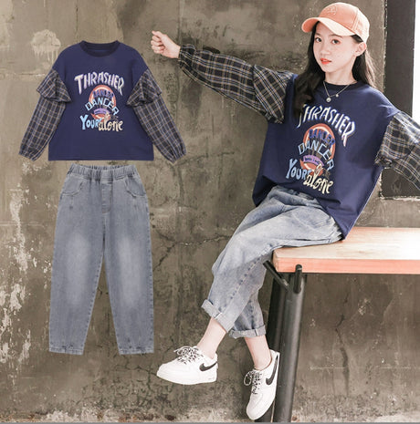 A two-piece set for girls, a wide, solid color print shirt with long sleeves in a checkered pattern with additional ruffles on the sleeves and gray jeans