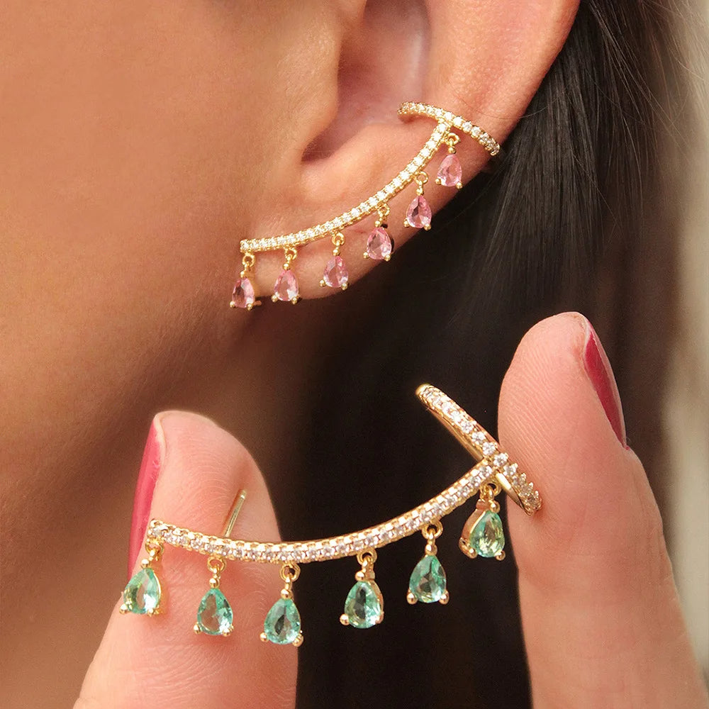 One long gold earring with an additional ring, decorated with crystals and dangling with colored zircon crystals.