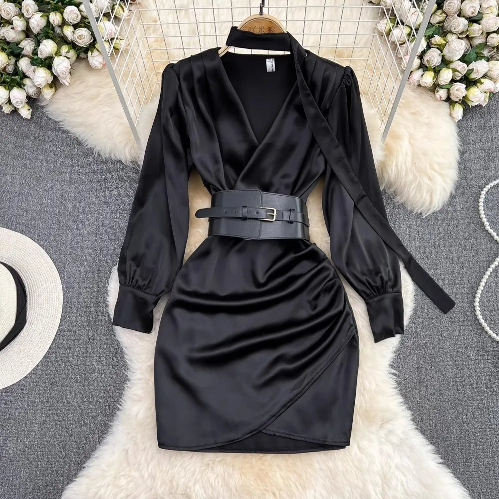 Short black satin dress with long sleeves and a belt at the waist
