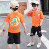 A two-piece set for a boy, black shorts with front and side pockets, and a T-shirt with a unicorn logo print on the front and back.