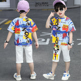 A two-piece boy's set, a T-shirt with random colors and phrases, and white shorts with a print on the front