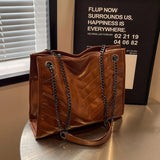 Large and practical shoulder bag in patent leather with shoulder chains