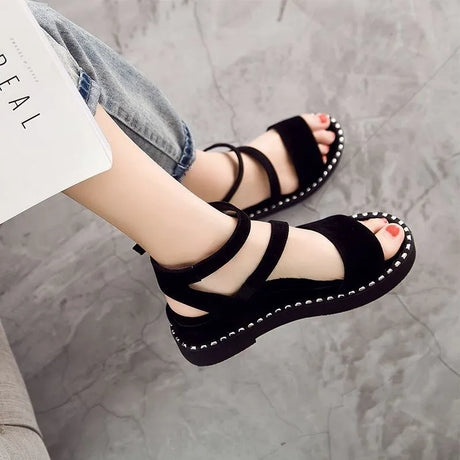 Elegant women's black sandal with a simple height and a white dotted line with an ankle strap