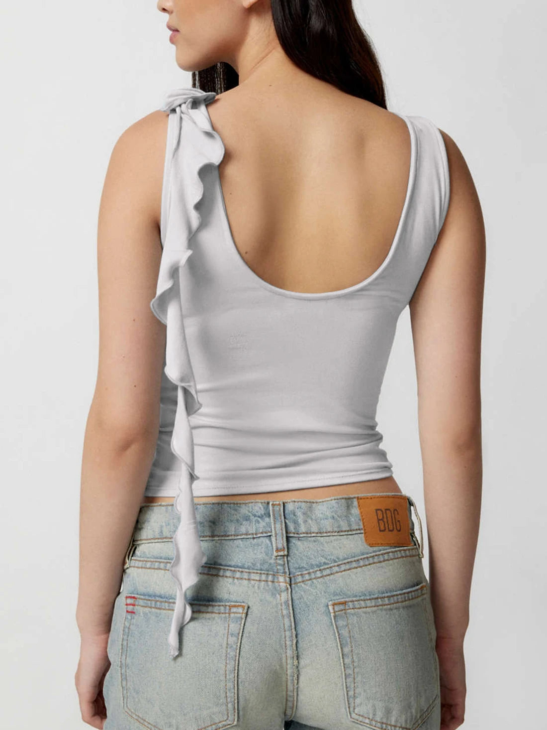 Women's sleeveless top with a round back and a ruffled bow on one shoulder