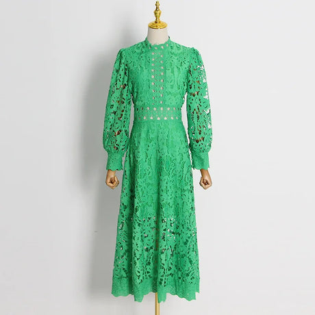 فستان طويل منسوج من قماش أخضر مقصوص، وأكمام طويلة، وأكتاف منتفخة، ورقبة دائرية مغلقة