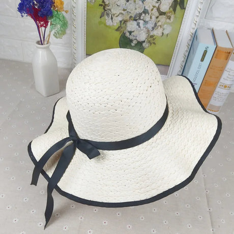 A summer straw hat decorated with a thin black ribbon and a bow