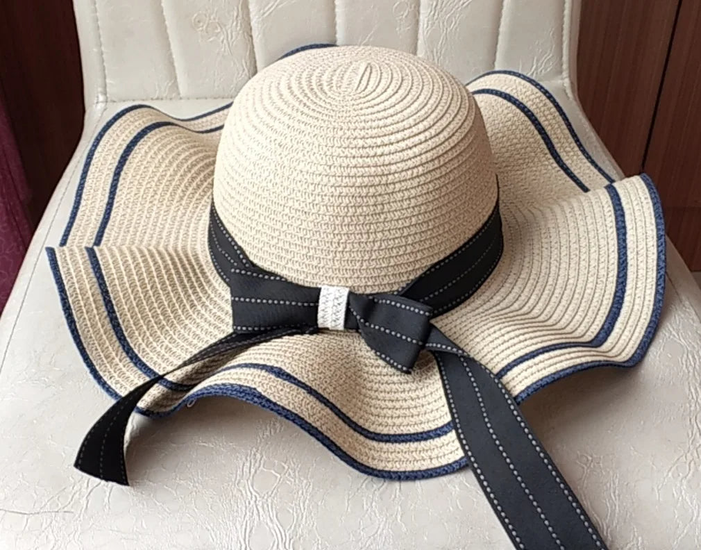 Summer straw hat with striped and wavy brim with a bow