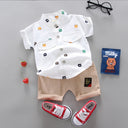 A two-piece set for a boy: a solid-color short-sleeved shirt with a random teddy bear print, and khaki shorts