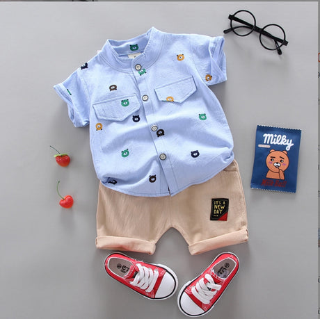 A two-piece set for a boy: a solid-color short-sleeved shirt with a random teddy bear print, and khaki shorts