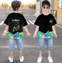 A two-piece boy's set: a solid-colored T-shirt with abstract art colors at the bottom and a cartoon character print on the back, and light-colored denim shorts