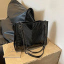 Large and practical shoulder bag in patent leather with shoulder chains