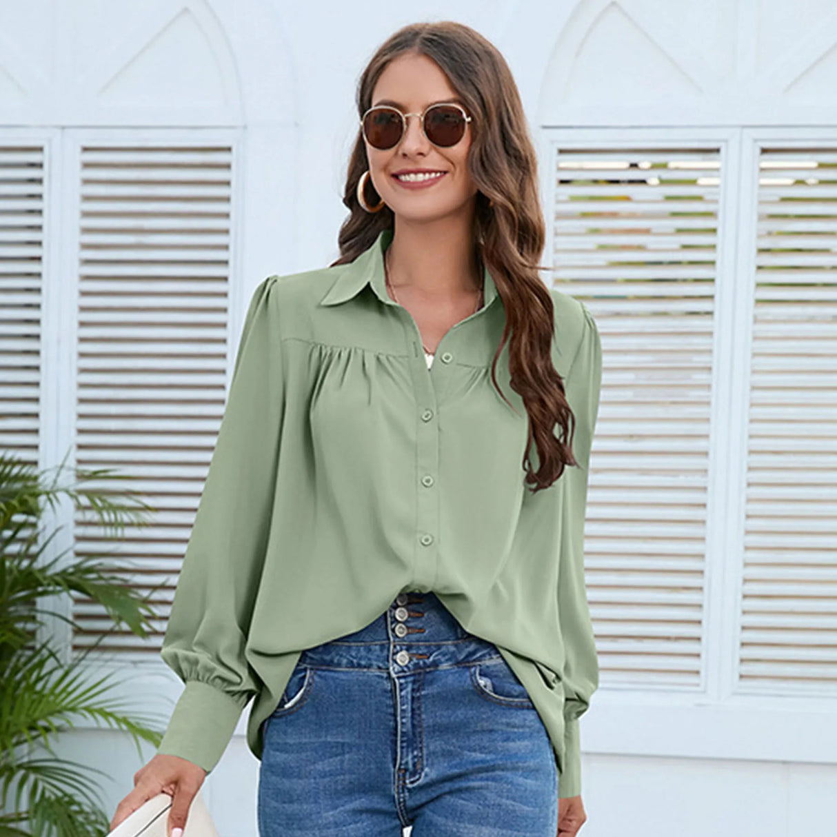 A plain, wide women's shirt with ruffles at the chest area, long puff sleeves and buttons on the front