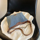 Brown denim and leather bag with a silver chain and zipper closure