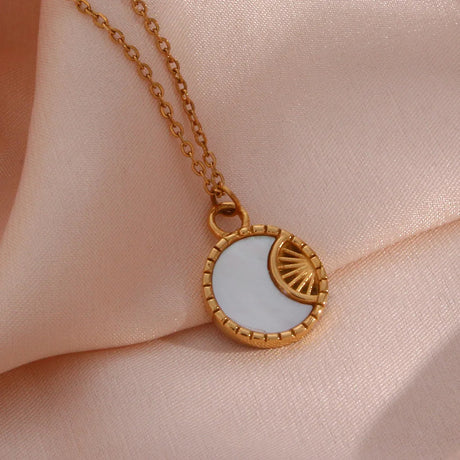 A gold-colored necklace decorated with a moon and sun pendant