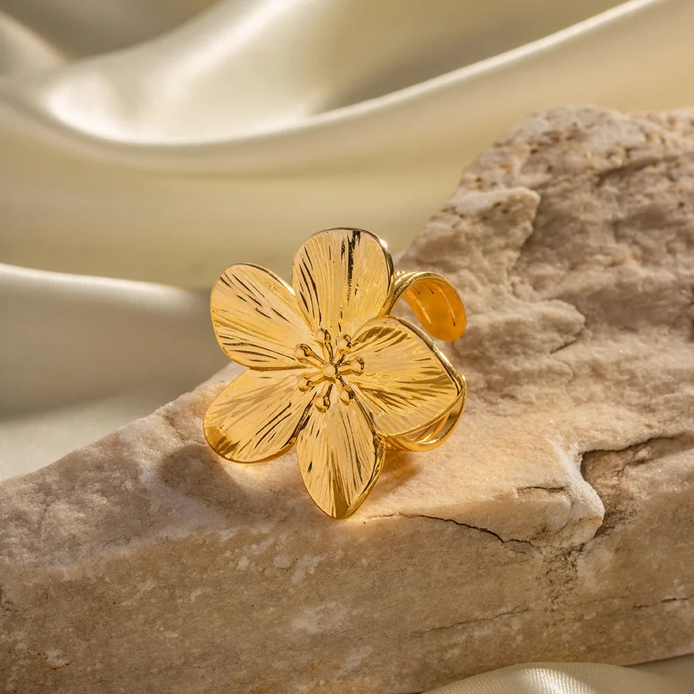 Women's gold-colored jewelry ring with an open ring in the shape of a rose