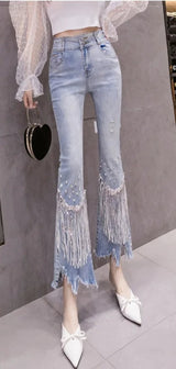 Fashionable high-waist jeans with beaded detailing, fringe trim and random hem
