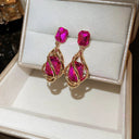 Distinctive gold-colored dangling earrings decorated with colored crystal stones