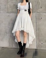 White dress with a square chest, puff sleeves, a short end in the front and a long end in the back, and a lace edge