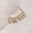 One long gold earring with an additional ring, decorated with crystals and dangling with colored zircon crystals.