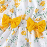 فستان صيفي للفتيات باللون الأبيض مع طبعات زهور صفراء عشوائية وكشكشة على الأكتاف وفيونكات من الأمام، مع ربطة رأس بنفس الطراز