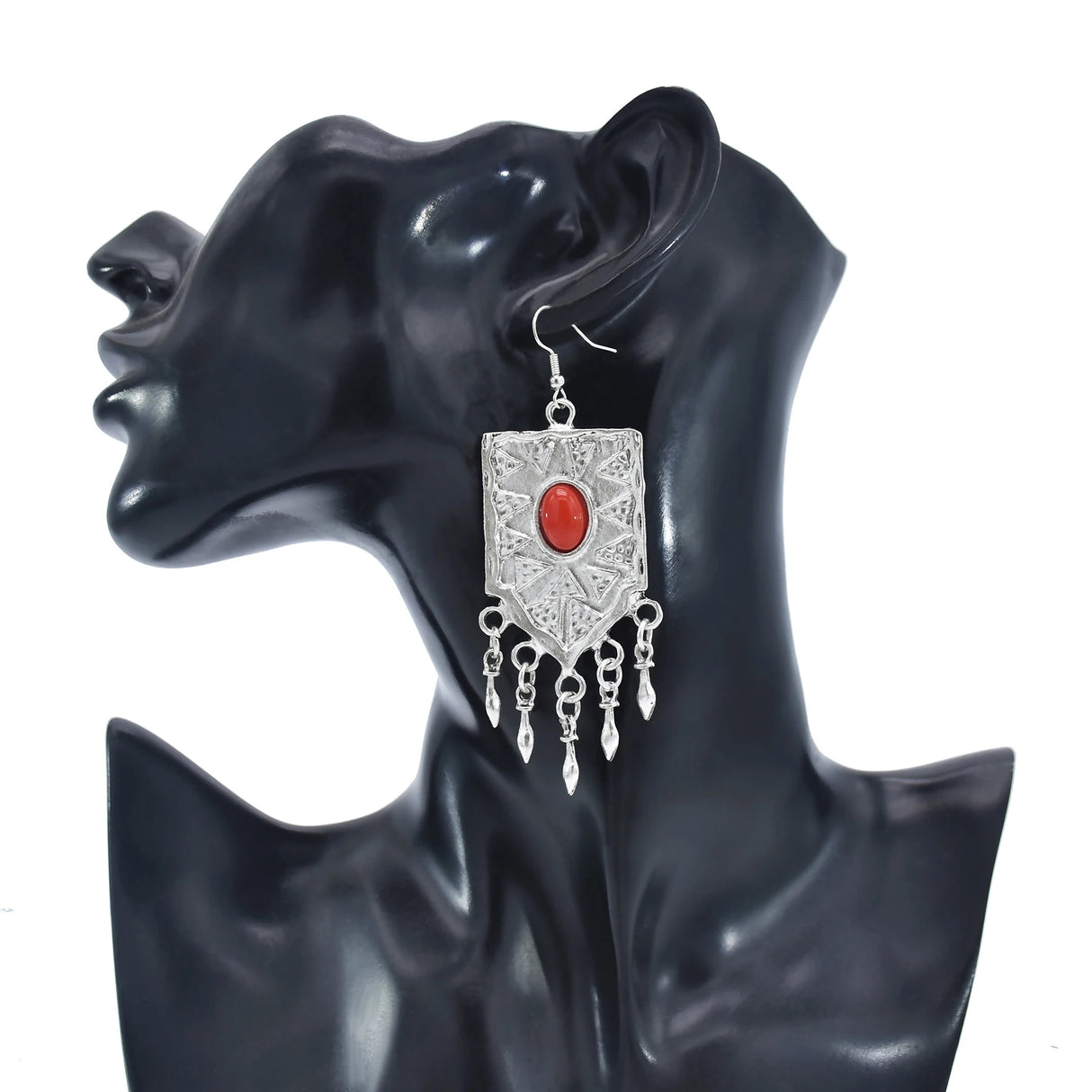 A three-piece bohemian accessory set, silver colored with red stones, a long necklace with four strands, earrings and a bracelet with three rings.