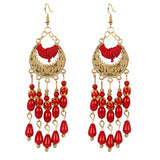 Women's gold embroidered dangling earrings decorated with beads and colored rhinestone