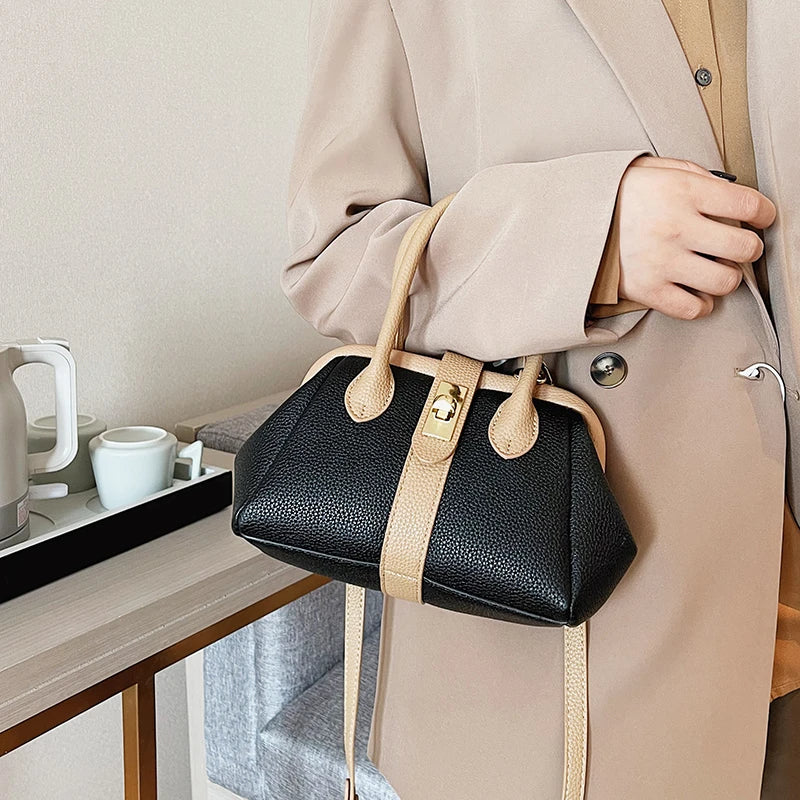 A modern handbag made of leather and a gold buckle with a shoulder strap