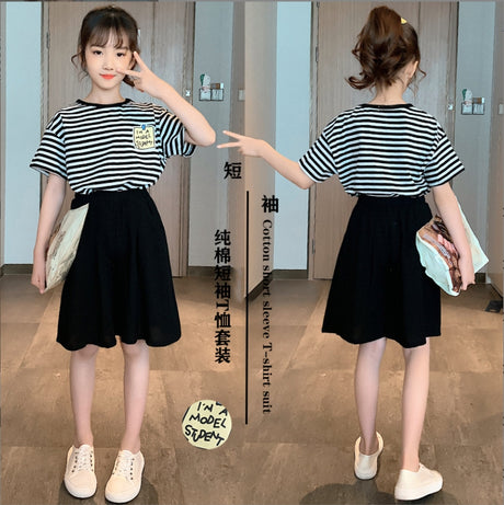 A girls' two-piece set, a black and white striped T-shirt with short sleeves and wide, long black shorts with front pockets.