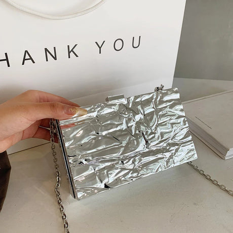 A tight metallic box-shaped bag with a chain