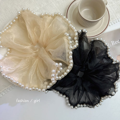 A set of two pieces, a large and elegant hair tie with a transparent fabric decorated with pearls at the ends