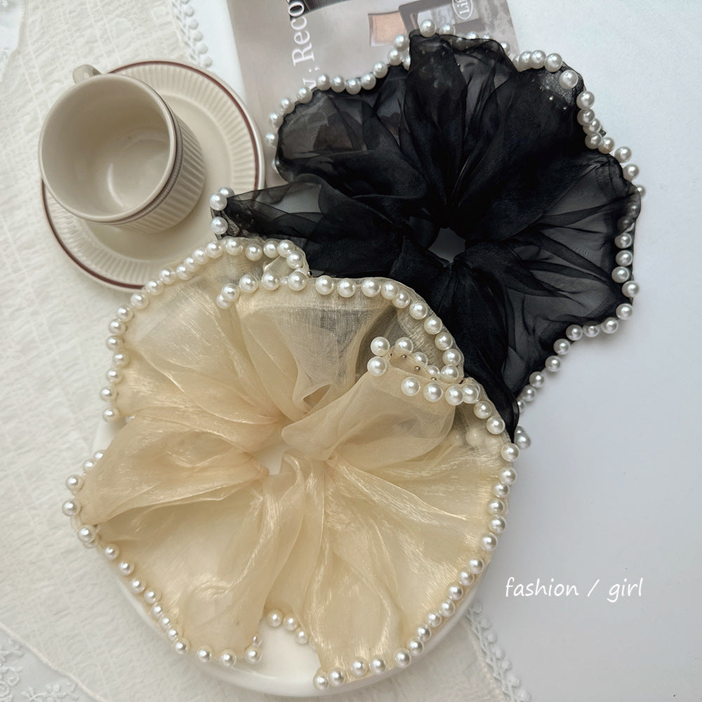 A set of two pieces, a large and elegant hair tie with a transparent fabric decorated with pearls at the ends