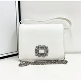 A square leather handbag studded with crystals arranged in a rectangular shape with an additional chain