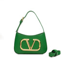 Solid color leather handbag with a large gold logo and an additional shoulder strap