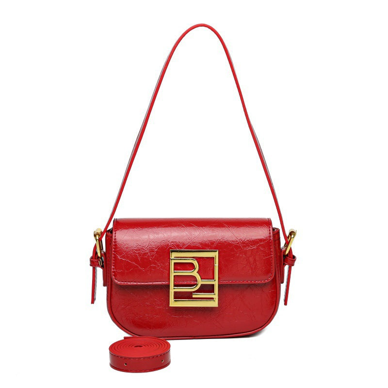 Leather crossbody bag with curved edges, a large gold logo, and an additional strap