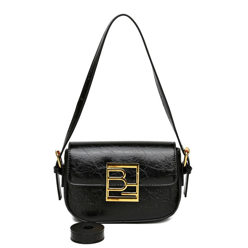 Leather crossbody bag with curved edges, a large gold logo, and an additional strap