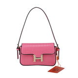 Leather shoulder bag with black borders and H-shaped button closure