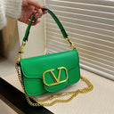 Solid color leather handbag with a large gold logo and an gold shoulder chain