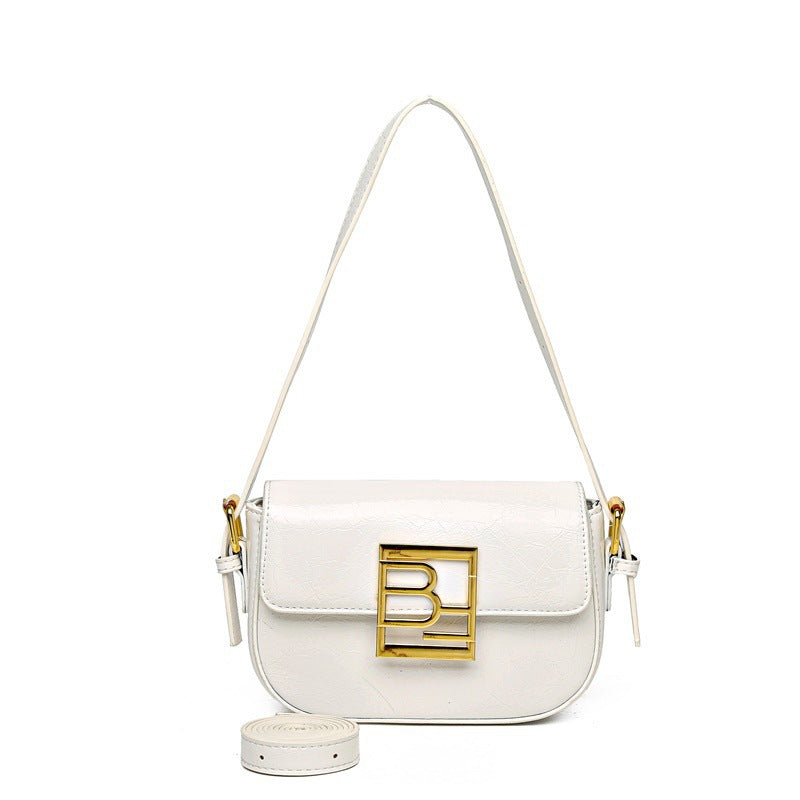 Leather crossbody bag with curved edges, a large gold logo, and an additional strap