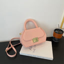 Fashionable solid color leather crossbody bag with elegant gold button closure and curved handle