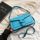 Solid color leather crossbody handbag with with similar colored logo and dark borders