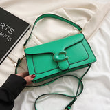 Solid color leather crossbody handbag with with similar colored logo and dark borders