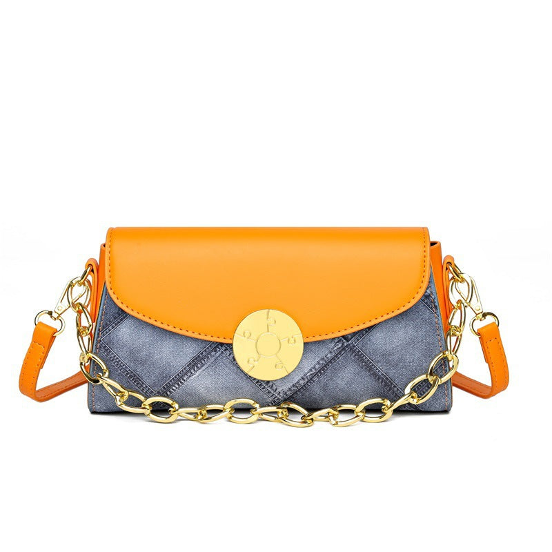 Denim print leather crossbody bag with full color flap and round gold button closure with short chain and shoulder strap
