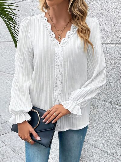 A practical and elegant women's shirt in a solid color with longitudinal stripes and long sleeves that end with ruffles
