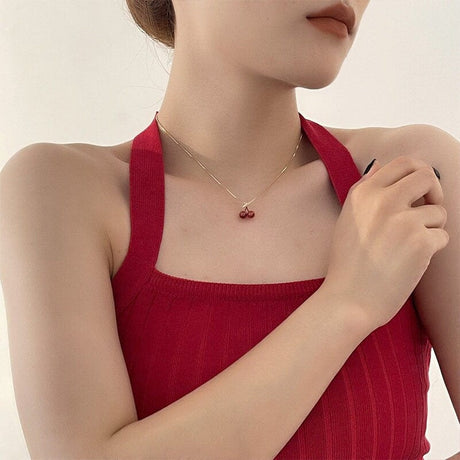 A soft cherry red pendant with a delicate gold chain